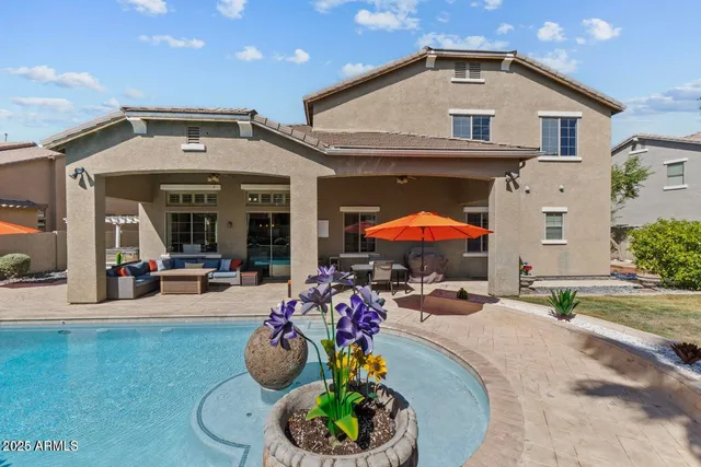 a backyard of a house with table and chairs plants