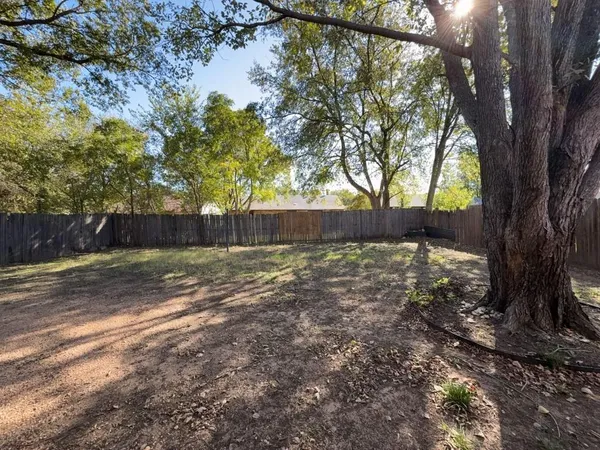 a view of a yard with wooden fence