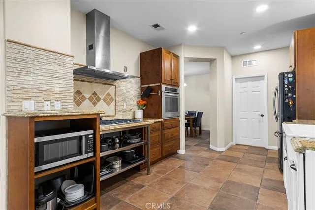 a kitchen with stainless steel appliances granite countertop a stove and a refrigerator