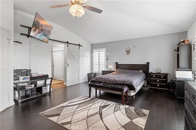 a spacious bedroom with a bed and wooden floor