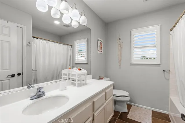 a bathroom with a sink vanity mirror and toilet
