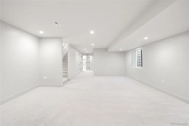 an empty room with windows and white walls