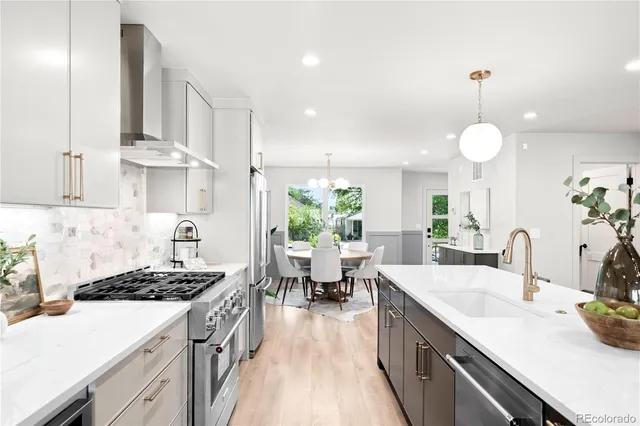a kitchen with a sink stove and white cabinets with wooden floor