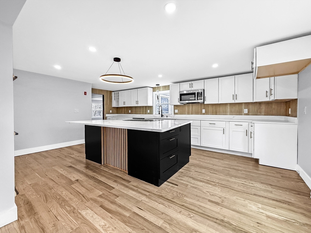 21 Burlington Road Billerica, MA 01821 - Photo 13 of 42 a kitchen with a stove a sink a refrigerator and white cabinets with wooden floor