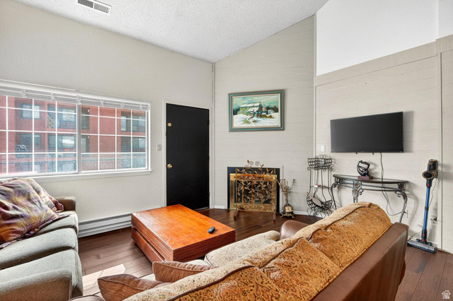 407 South Vasels Road, Unit 24 Brian Head, UT 84719 - Photo 7 of 63 Living room with dark wood-type flooring, a fireplace, and a baseboard heating unit