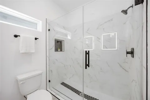 a bathroom with a toilet a sink and shower