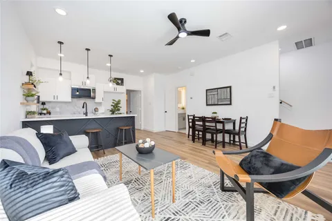a living room with furniture a rug and kitchen view