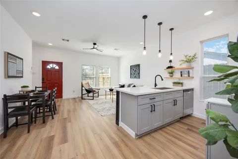 a large kitchen with kitchen island a white counter space a sink stainless steel appliances and cabinets