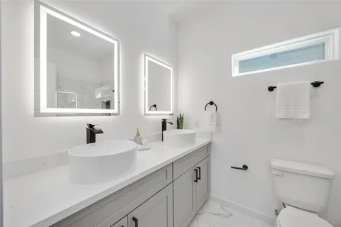 a bathroom with a sink a toilet and a mirror