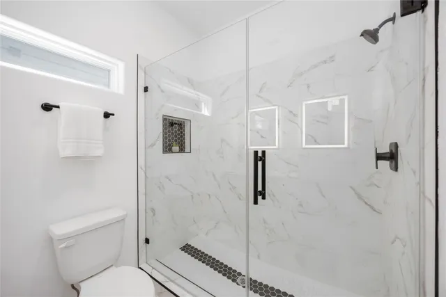 a bathroom with a toilet a sink and shower