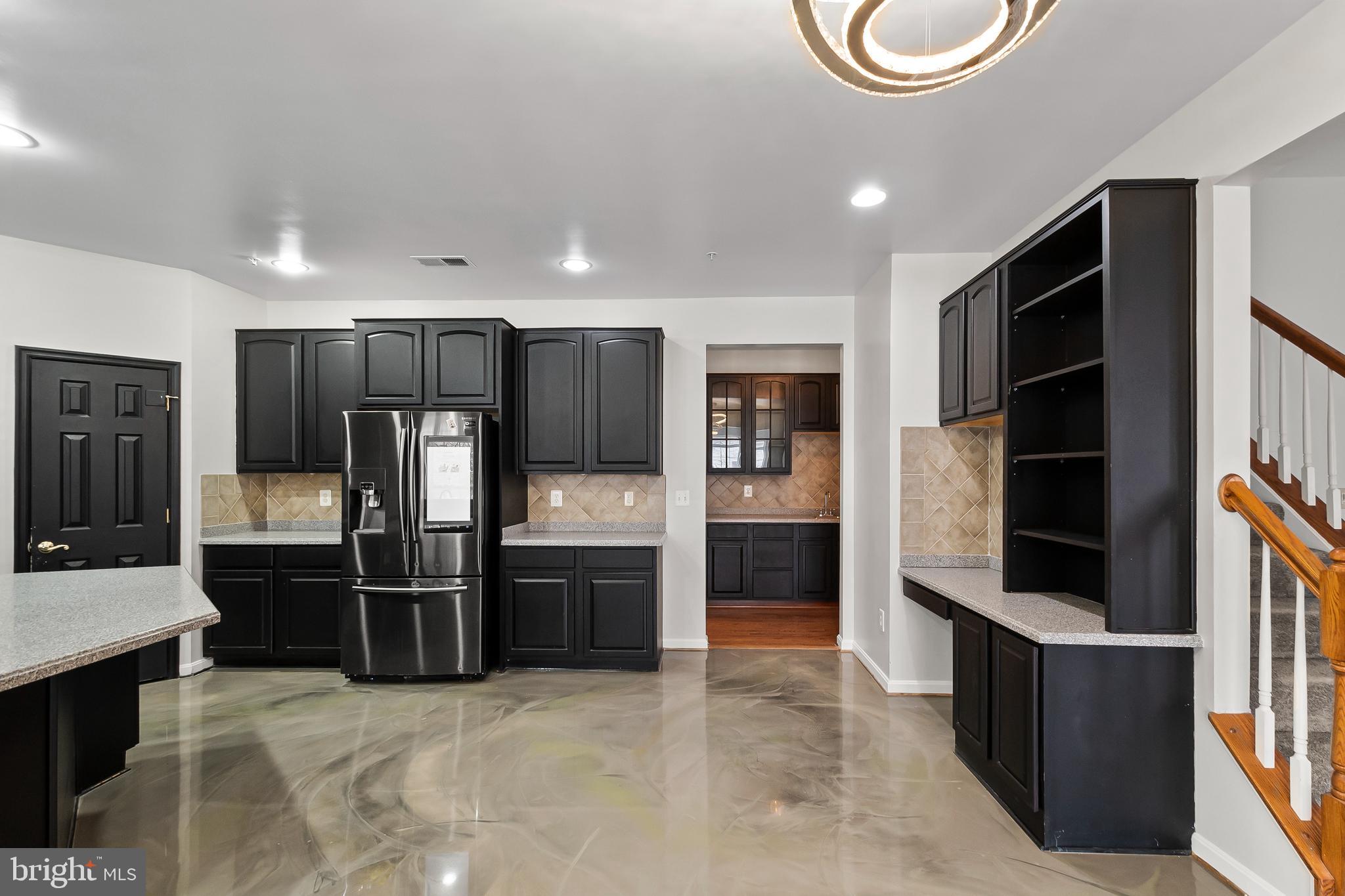 9015 Helmsley Drive Clinton, MD 20735 - Photo 11 of 53 a kitchen with stainless steel appliances kitchen island granite countertop a refrigerator and a sink