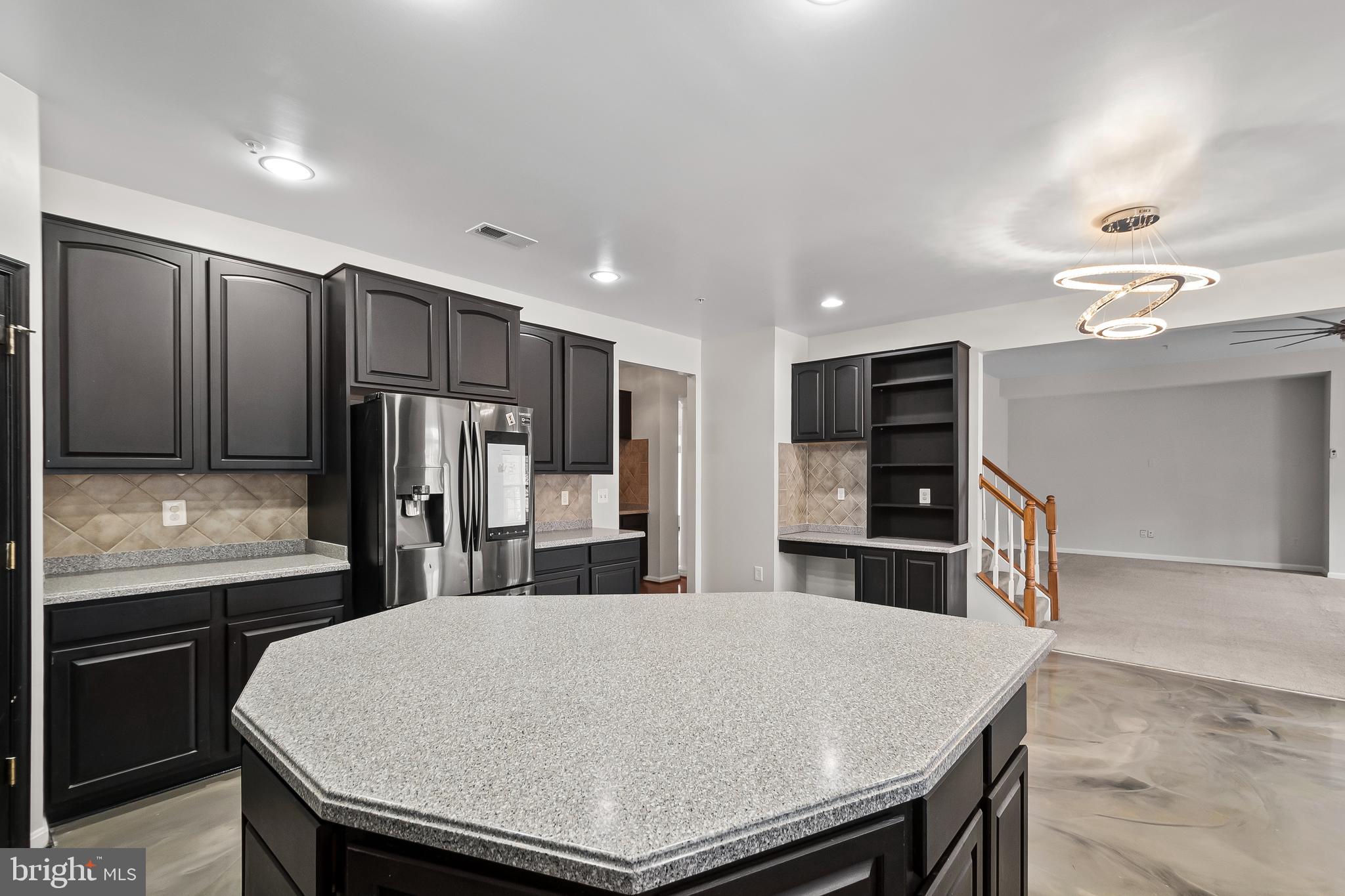 9015 Helmsley Drive Clinton, MD 20735 - Photo 12 of 53 a kitchen with stainless steel appliances kitchen island granite countertop a refrigerator a stove and a sink with wooden floor