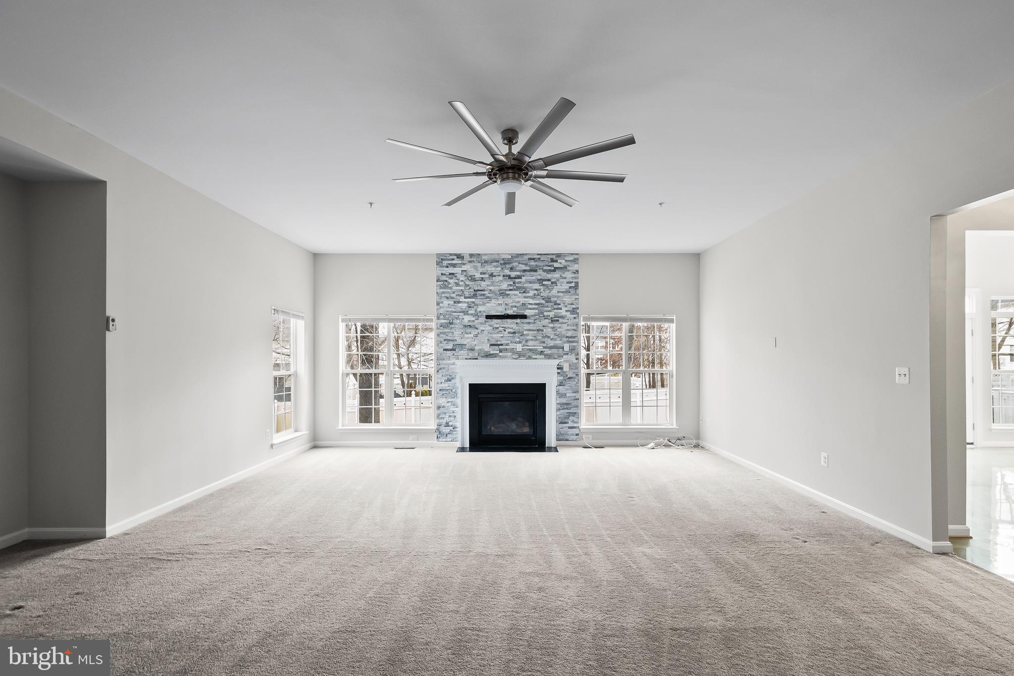9015 Helmsley Drive Clinton, MD 20735 - Photo 17 of 53 a view of a livingroom with a fireplace and a ceiling fan