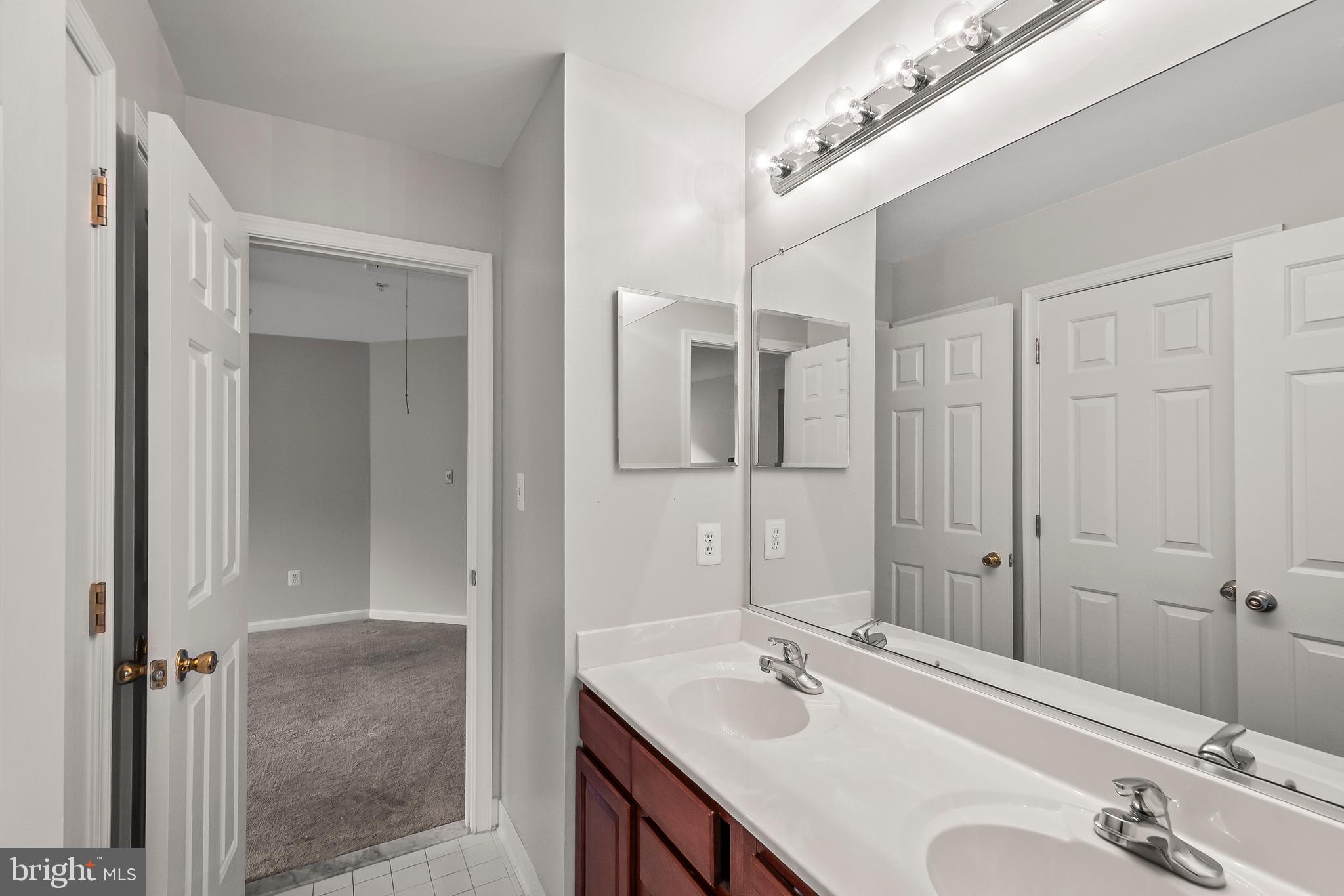 9015 Helmsley Drive Clinton, MD 20735 - Photo 28 of 53 a bathroom with a sink vanity granite shower and a mirror
