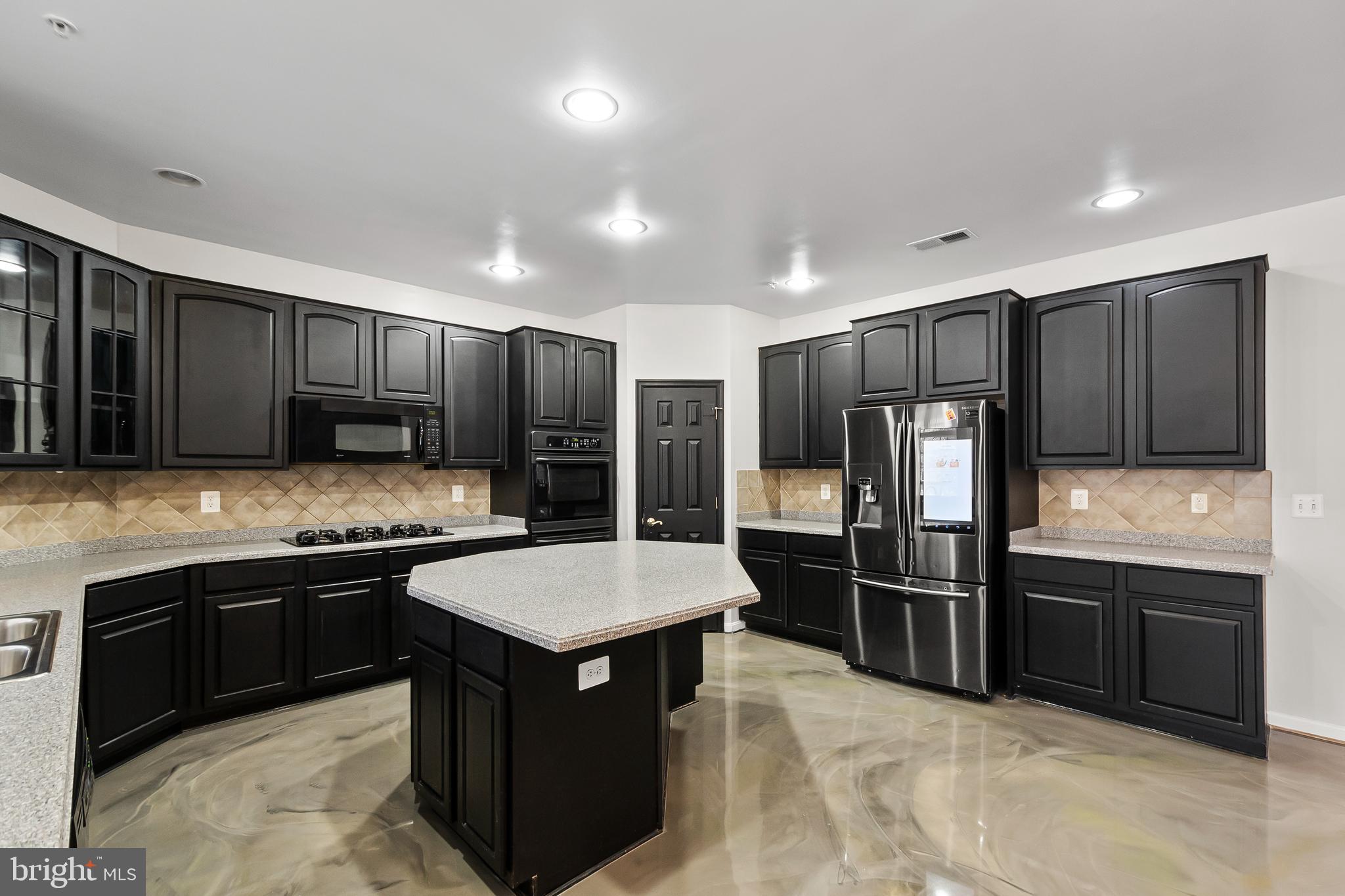 9015 Helmsley Drive Clinton, MD 20735 - Photo 10 of 53 a kitchen with stainless steel appliances granite countertop a refrigerator and a sink