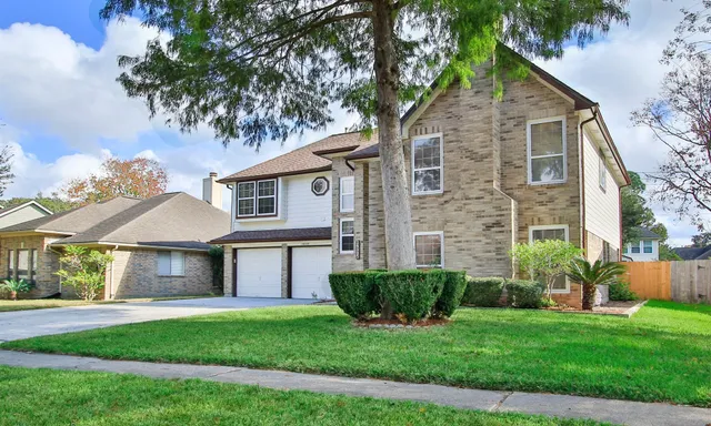 a front view of a house with a yard and garage