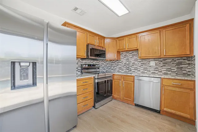 a kitchen with stainless steel appliances granite countertop a stove a sink and a microwave