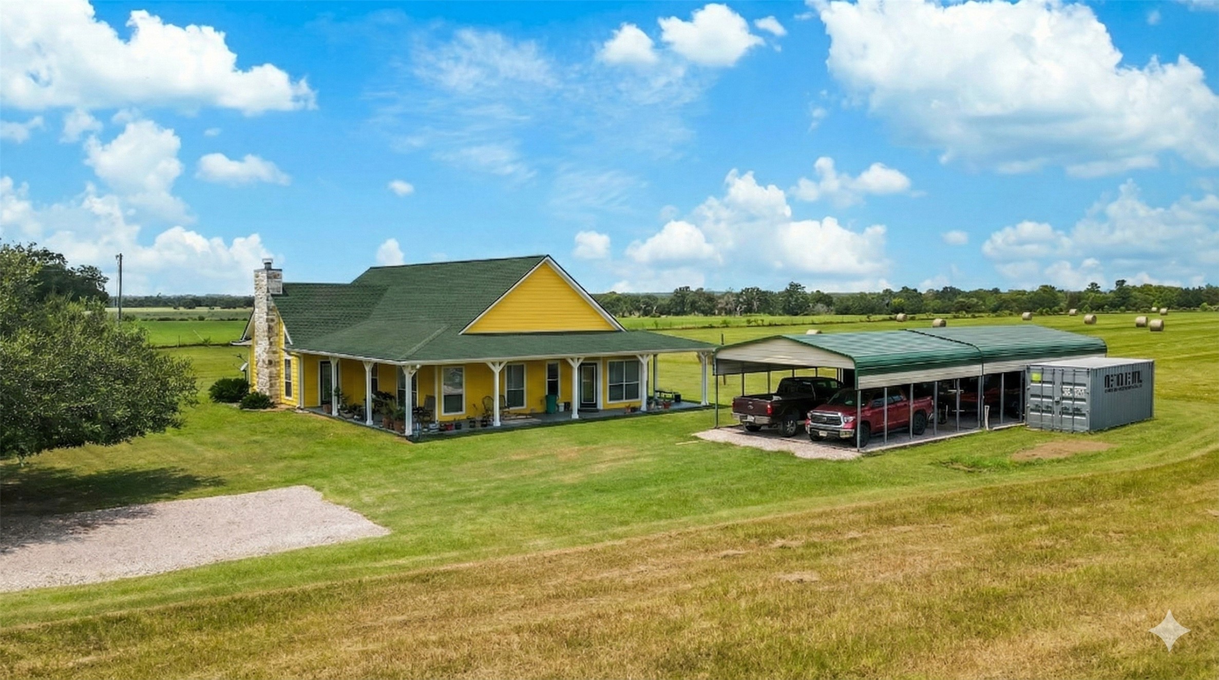 a view of a house with a big yard and large trees