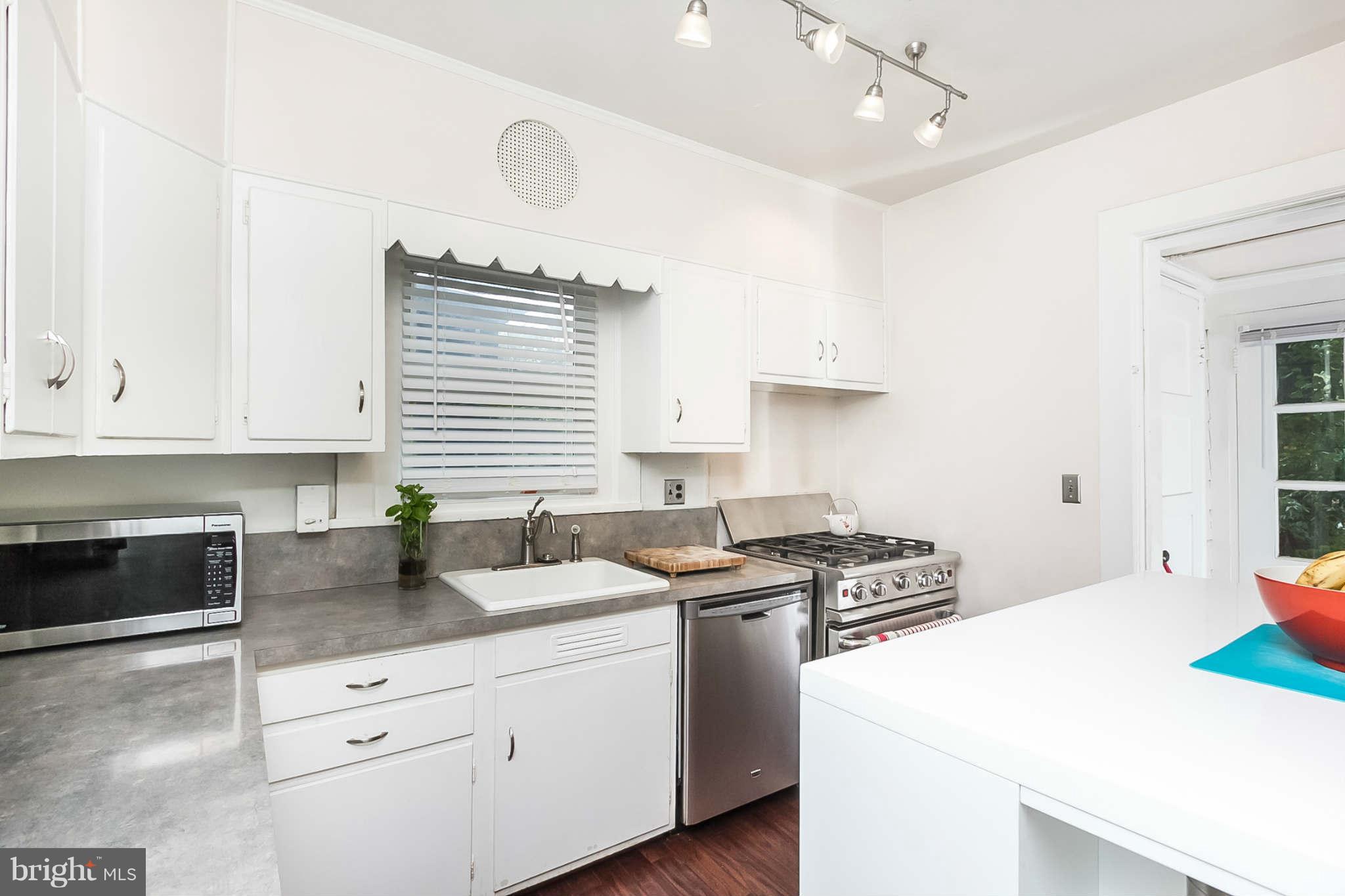 4819 Keswick Road Baltimore, MD 21210 - Photo 13 of 28 a kitchen with granite countertop a sink a stove and cabinets