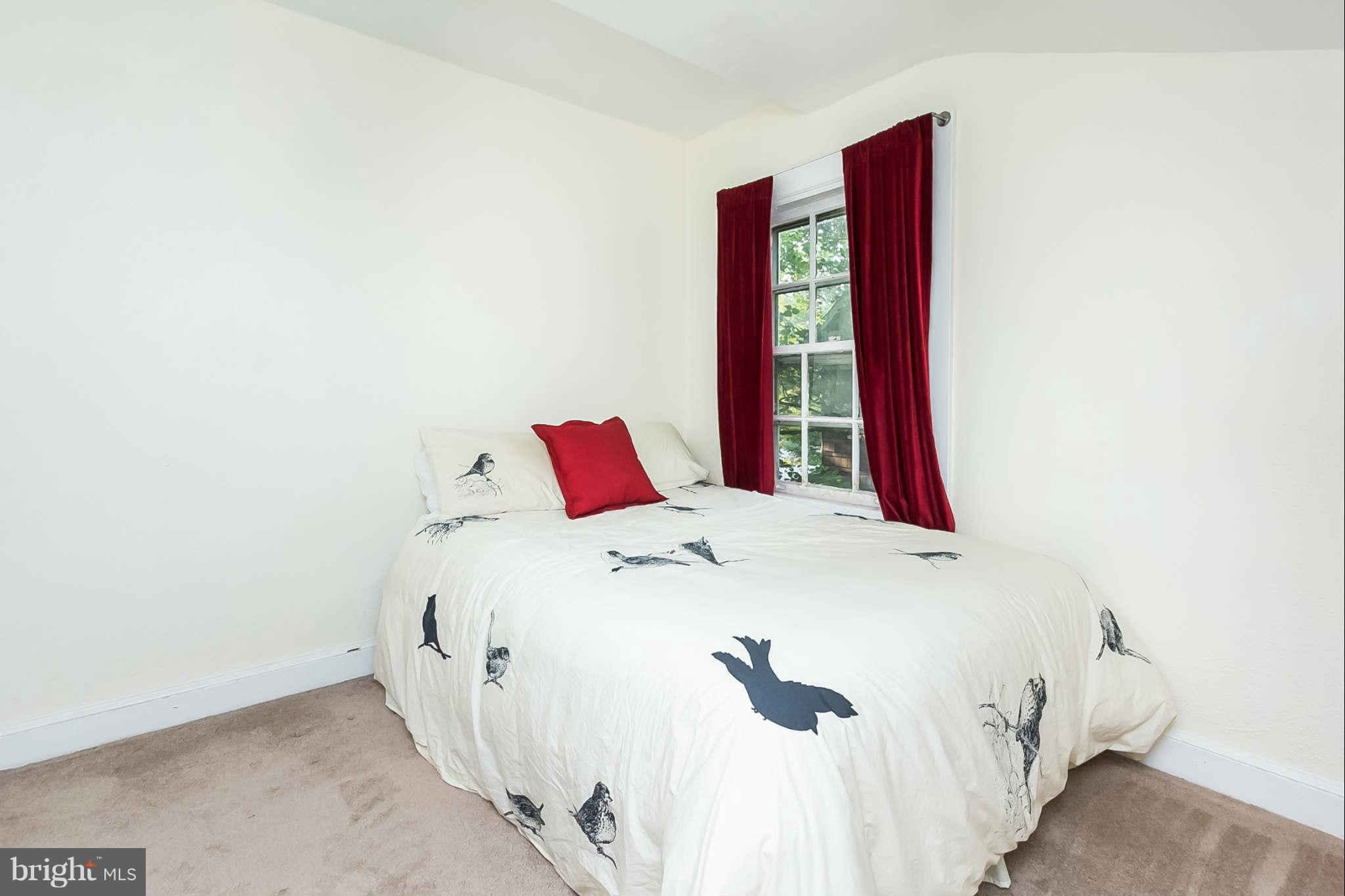 4819 Keswick Road Baltimore, MD 21210 - Photo 23 of 28 a bed sitting in a bedroom next to a white wall