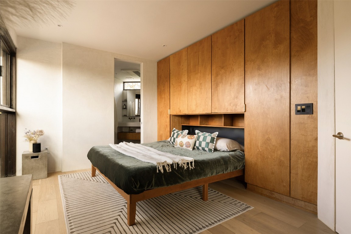 2302 East 11th Street Austin, TX 78702 - Photo 29 of 40 a bedroom with a bed and wooden floor