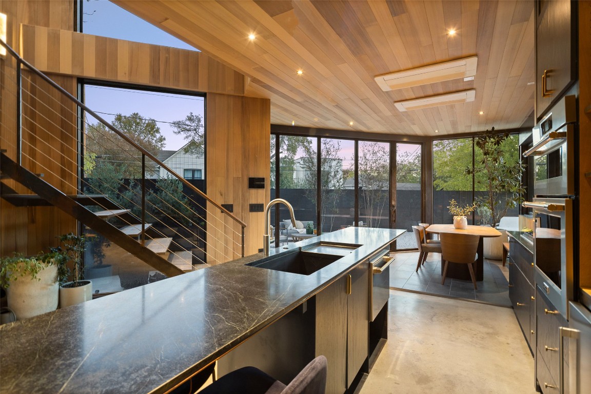 2302 East 11th Street Austin, TX 78702 - Photo 9 of 40 a kitchen with stainless steel appliances kitchen island granite countertop a sink and cabinets