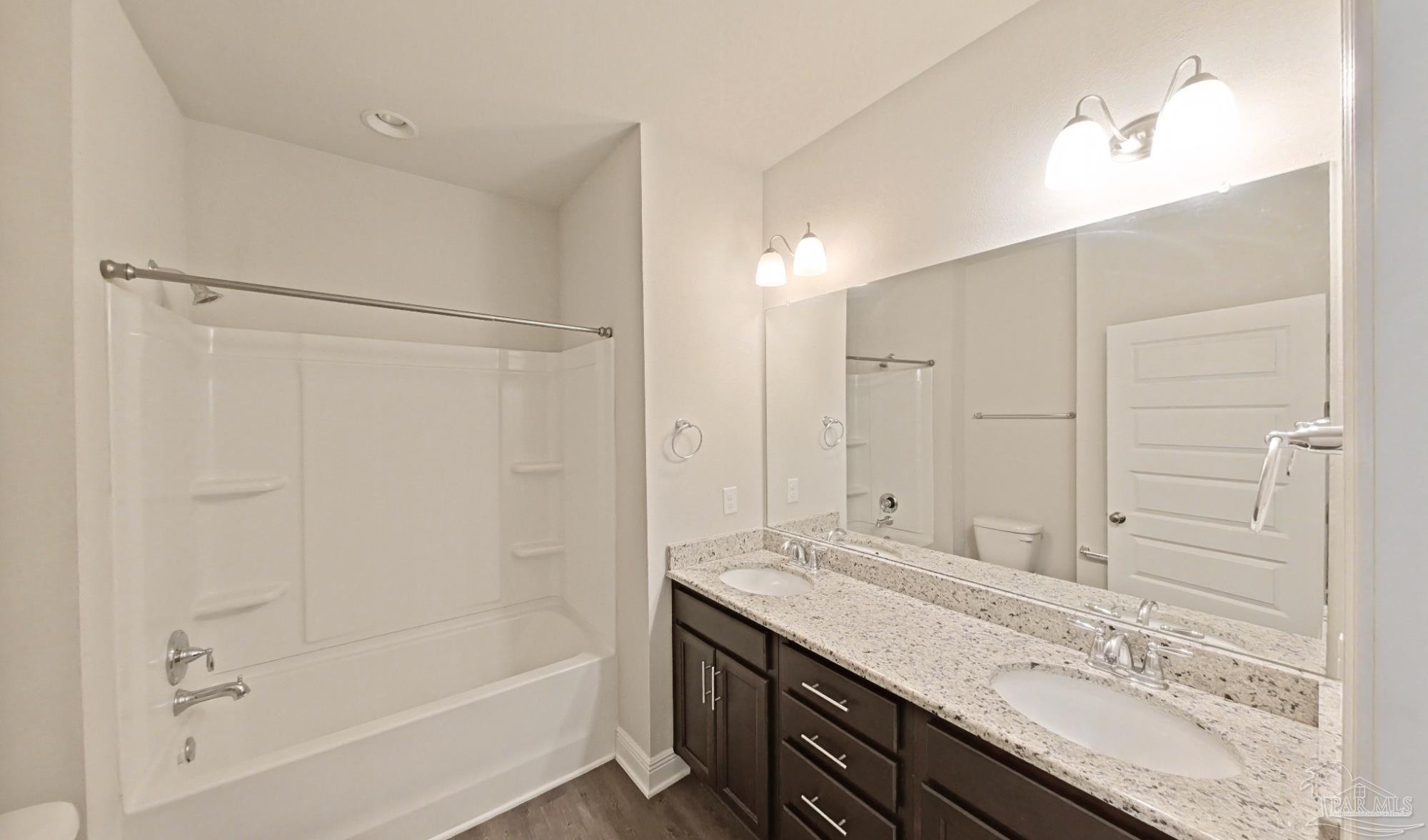 633 Harahan Lane Foley, AL 36535 - Photo 30 of 57 a bathroom with a granite countertop sink a mirror and a bathtub