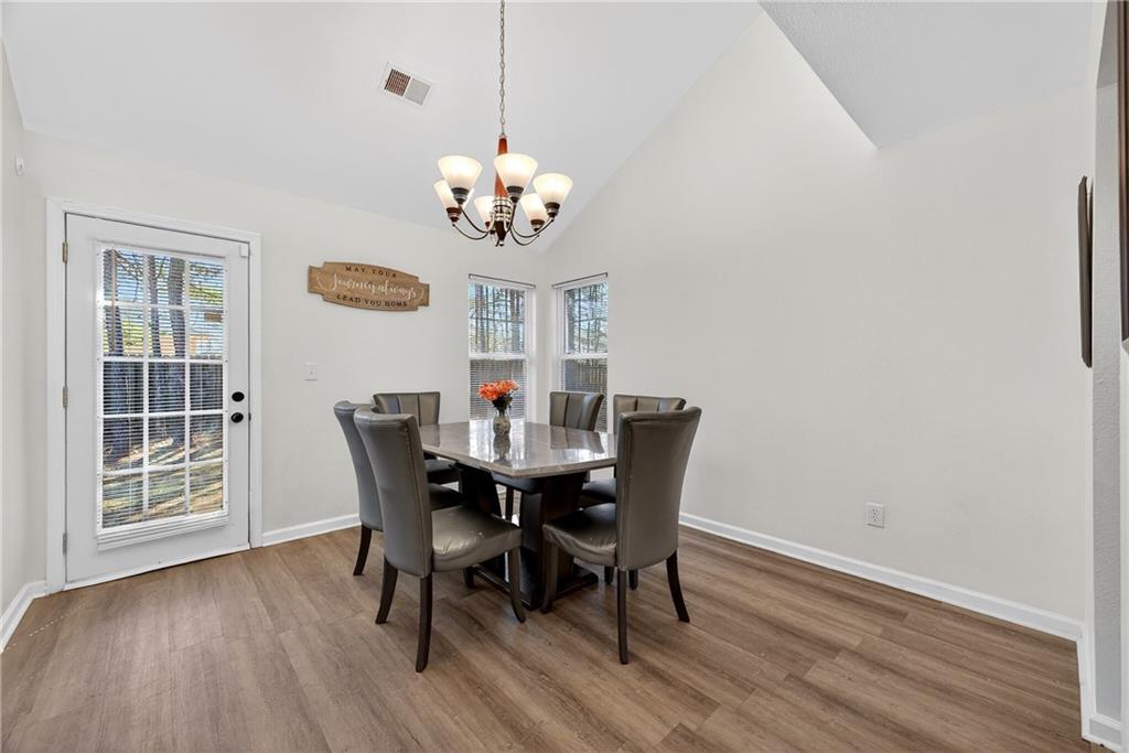 175 Gross Lake Parkway Covington, GA 30016 - Photo 9 of 25 a view of a dining room with furniture a chandelier and wooden floor