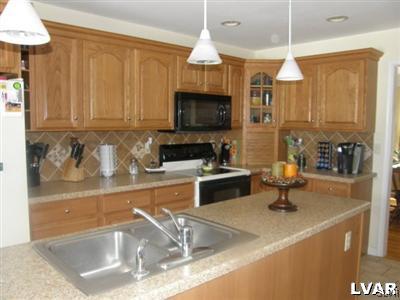 231 Kellington Road Wind Gap, PA 18091 - Photo 15 of 48 a kitchen with stainless steel appliances granite countertop a sink a stove and a refrigerator