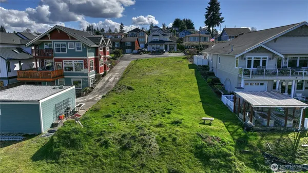 a view of a house with a big yard and large trees