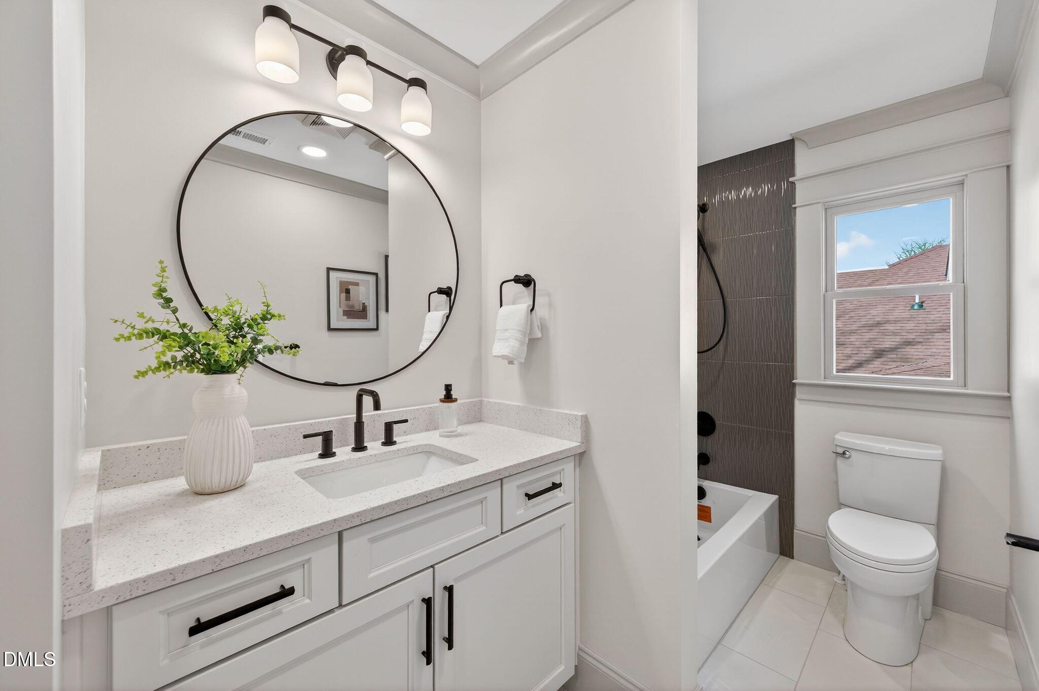 504 Tilden Street Raleigh, NC 27605 - Photo 37 of 58 a bathroom with a toilet a sink and mirror