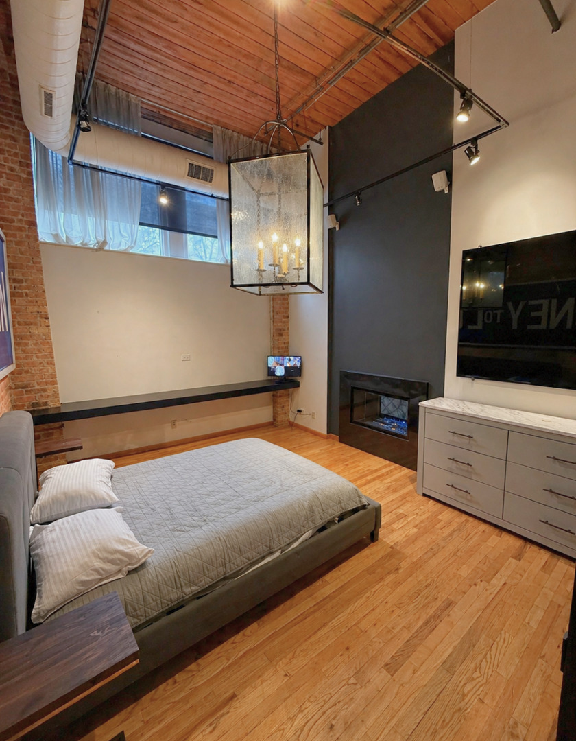 1327 West Washington Boulevard, Unit 106 Chicago, IL 60607 - Photo 11 of 23 a bedroom with a bed and a television