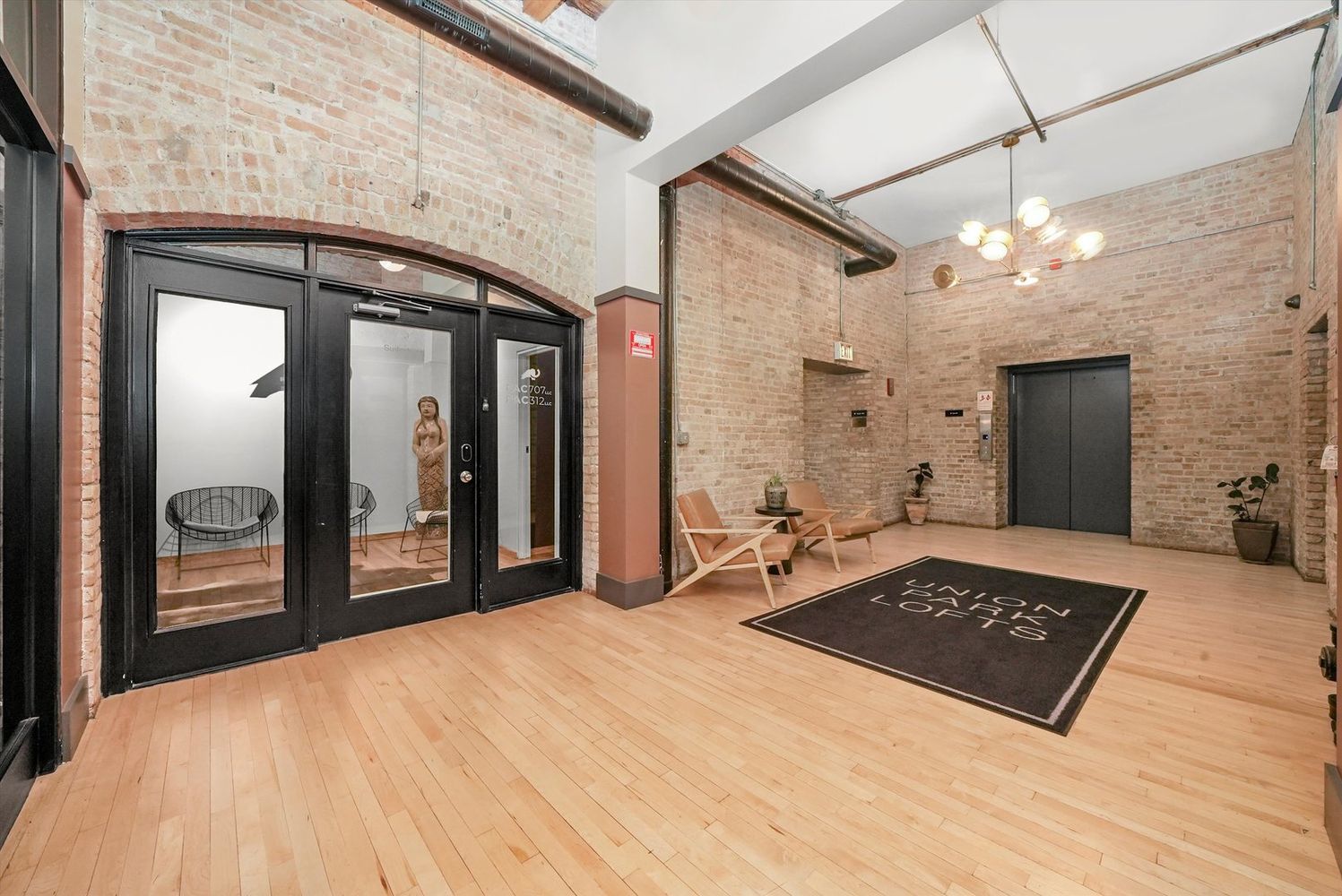 1327 West Washington Boulevard, Unit 106 Chicago, IL 60607 - Photo 3 of 23 a large bedroom with a bed and a chandelier