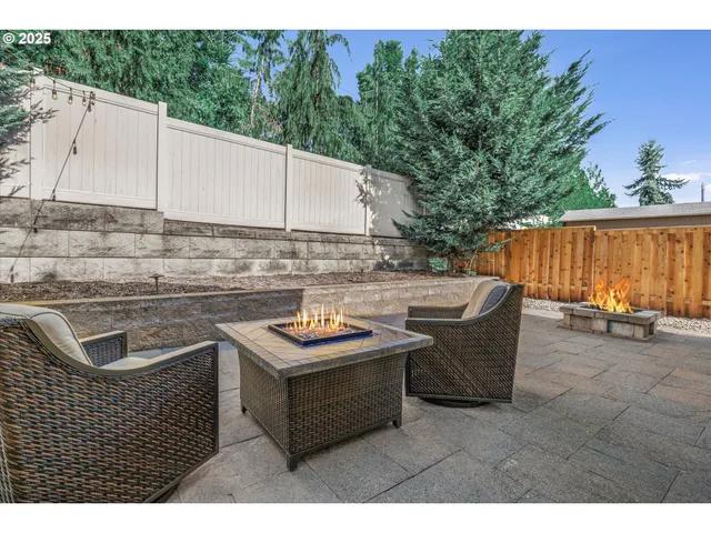 a view of a patio with table and chairs with wooden fence