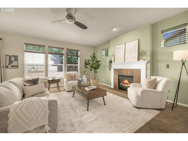 a living room with furniture a large window and a fireplace