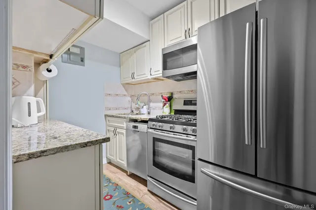 a kitchen with stainless steel appliances granite countertop a refrigerator and a stove