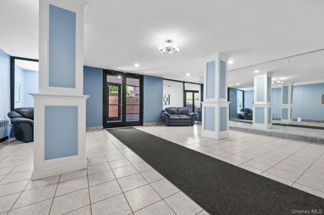 a large hall with stainless steel appliances kitchen island granite countertop a large window and a kitchen view