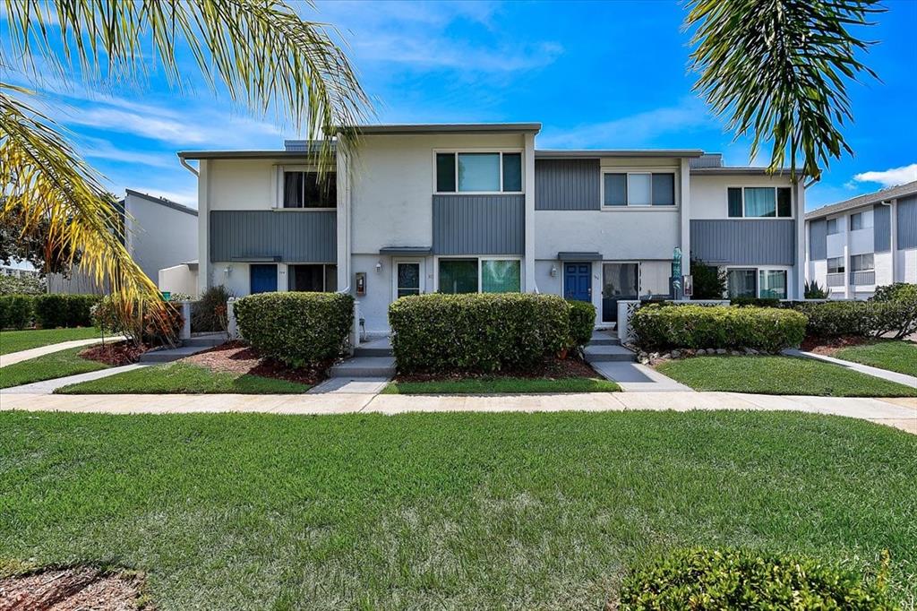 14800 Walsingham Road, Unit 304 Largo, FL 33774 - Photo 1 of 1 a front view of a house with a yard and garage