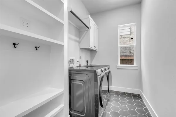 a utility room with stainless steel appliances washer and dryer
