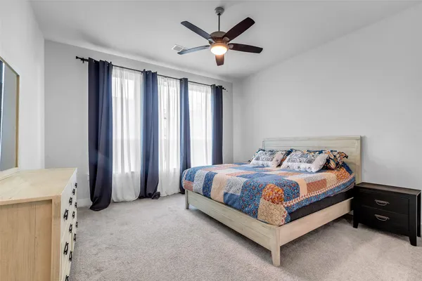 a bed sitting in a spacious bedroom next to a window
