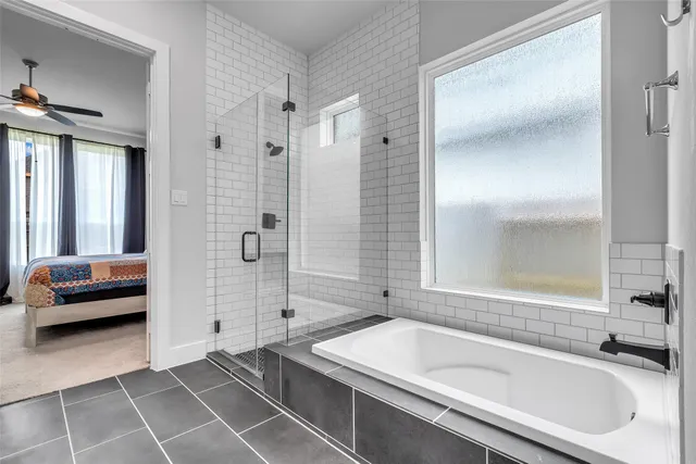 a bathroom with a tub a sink and a large mirror