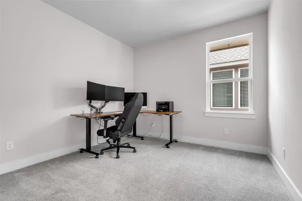 a view of a workspace with furniture and a window