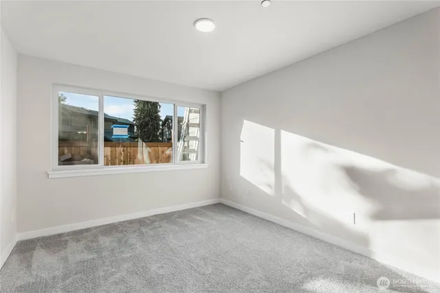 an empty room with window and bathroom