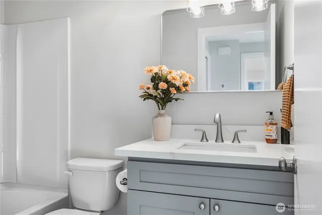 a bathroom with a toilet sink and mirror