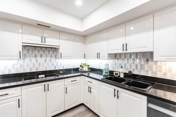 a white kitchen with sink and cabinets