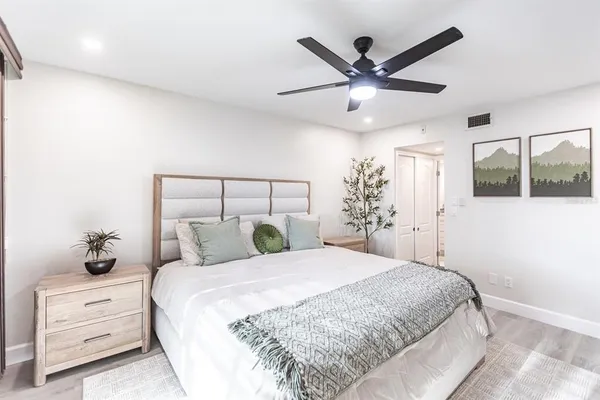 a bedroom with a large bed and a chandelier