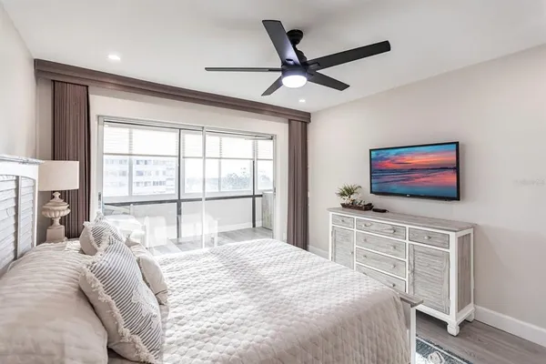 a bedroom with a large bed and a flat screen tv