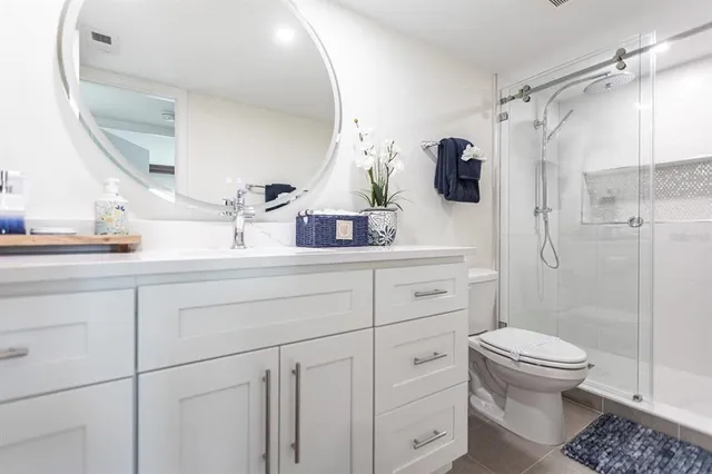 a bathroom with a sink a toilet and shower