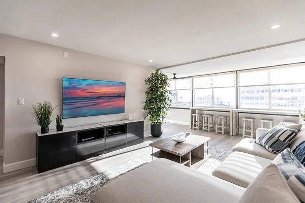 a living room with furniture a flat screen tv and a floor to ceiling window