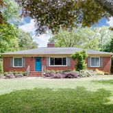 a front view of house with yard and trees in the background